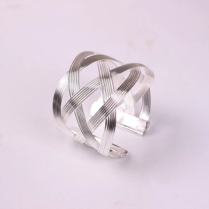 Detailed view of woven metal napkin ring featuring a multilayered architectural wire design