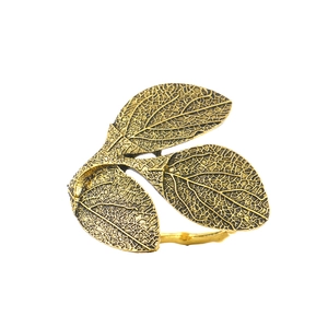 Vintage gold leaf napkin ring with intricate vein details on a clean white background