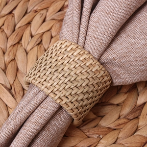 Handwoven bamboo napkin ring with linen napkin on a rustic woven placemat decoration