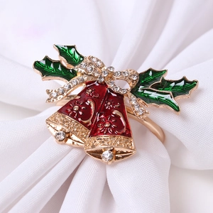 Christmas napkin ring with red bells and green leaves on white fabric background
