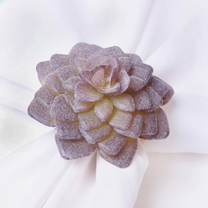 Dettaglio macro del portatovagliolo succulenta viola con texture su tessuto bianco
