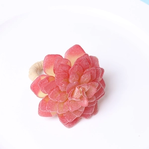 Dettaglio portatovagliolo succulenta con petali rosa e anello in rattan intrecciato