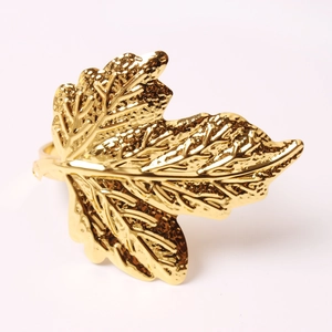 Detailed close-up of golden maple leaf napkin ring with realistic metallic leaf texture