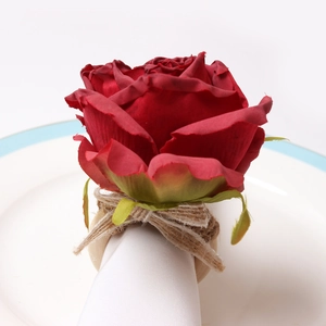 Detailed view of handmade red fabric rose napkin ring with wooden loop and rustic rope