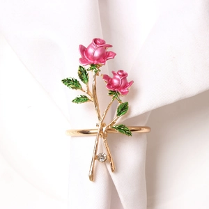 Close-up of pink enamel rose napkin ring with gold stem and sparkling crystal detail