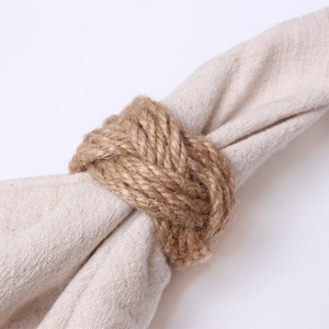 Macro detail of natural woven jute napkin ring showing rustic fiber texture and handmade knot