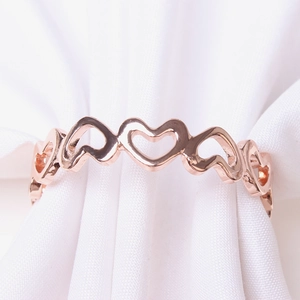 Rond de serviette cœur en or rose avec cœurs creux reliés pour décoration de table