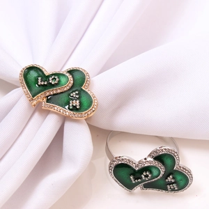 Macro detail of heart-shaped napkin ring with green enamel and LOVE crystal inlay