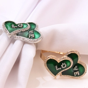Golden and silver heart-shaped napkin rings with green enamel and LOVE rhinestones