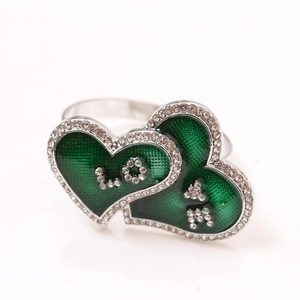 Detail of silver heart napkin ring with green enamel, sparkling rhinestones, and LOVE letters