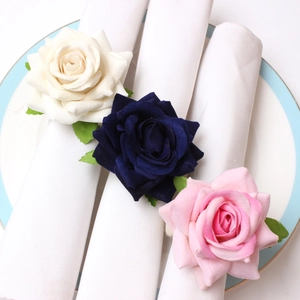 Detail of handmade velvet rose napkin rings in cream, navy blue and pink for table decor