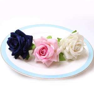 Detailed view of handmade blue and pink silk rose napkin rings on a white porcelain plate
