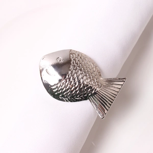 Detail des silbernen Fischnetzknotens mit feiner Schuppentextur auf weißem Stoff