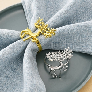 Elegant gold and silver forest reindeer napkin rings set on light blue linen napkins