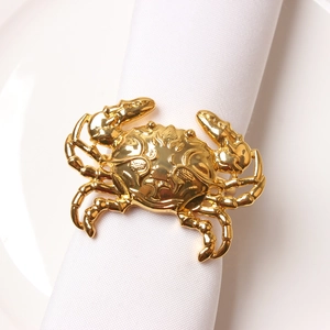 Golden crab metal napkin ring on white fabric for elegant dining table decoration
