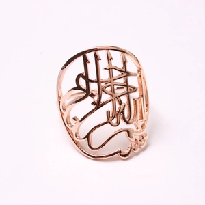 Détail du rond de serviette évidé avec calligraphie arabe au fini or rose élégant