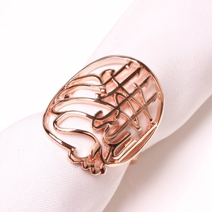 Vue détaillée du rond de serviette en or rose avec design calligraphique arabe ajouré