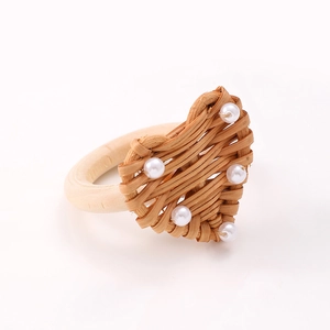 Handmade rattan heart napkin ring with white pearls and natural wood base for table decor