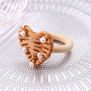 Handmade heart-shaped rattan napkin ring with elegant pearl accents and wooden ring base