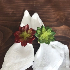 Succulent napkin ring set with red and green faux plants on white cotton napkins