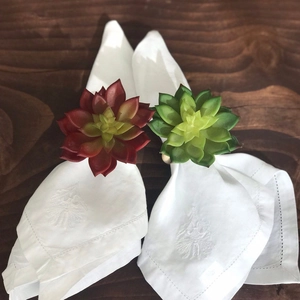 Succulent napkin rings with wooden loops and white embroidered linen napkins