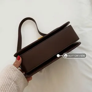 Detail of the wide base design on a vintage brown minimalist faux leather crossbody bag