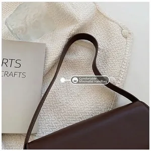 Detail of the minimalist brown leather shoulder bag handle with retro elegant aesthetic
