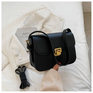 Close-up of black leather crossbody bag with elegant gold square metal buckle and strap