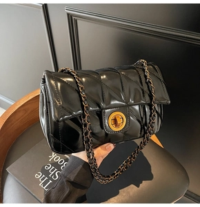Détail du sac matelassé en cuir ciré brillant avec fermoir rotatif doré circulaire