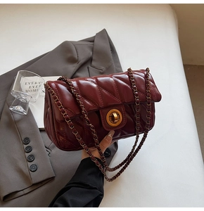 Détail du sac en cuir matelassé bordeaux avec fermoir doré et bandoulière en chaîne