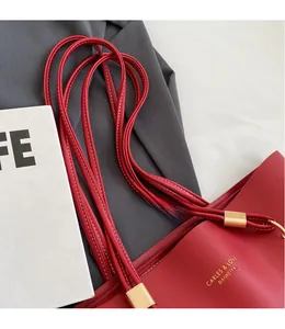 Détail d'un grand sac fourre-tout de mariage rouge avec cuir souple et boucle dorée