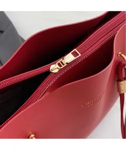 Détail du sac cabas rouge avec texture grainée et fermeture éclair en métal doré élégante