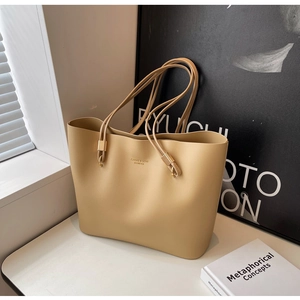 Détails du sac cabas en cuir beige mat avec finitions dorées et logo élégant