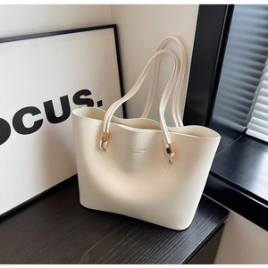 Détail d'un sac cabas en similicuir blanc crème avec des finitions dorées élégantes