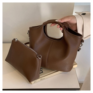 Detailed macro of brown lychee grain leather handbag set with round cutout handle