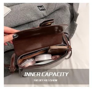 Macro view of inner compartment with zipper pocket in dark brown crossbody square bag