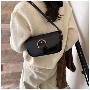 Minimalist black matte leather flap bag with iconic golden horseshoe buckle detail