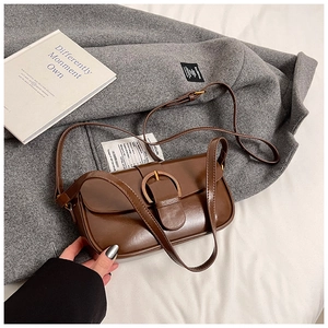 Detailed view of the brown vintage underarm bag with decorative metal ring buckle