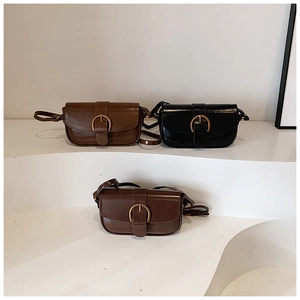 Detailed view of three vintage crossbody bags in black and brown with gold metal buckles