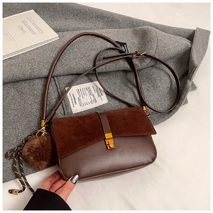 Detailed view of dark brown frosted crossbody bag with gold buckle and plush charm