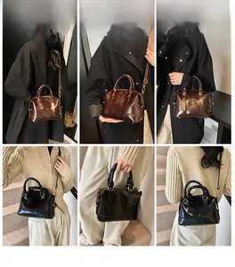 Borsa a secchiello in pelle nera e marrone scuro con dettagli di fibbie in metallo dorato
