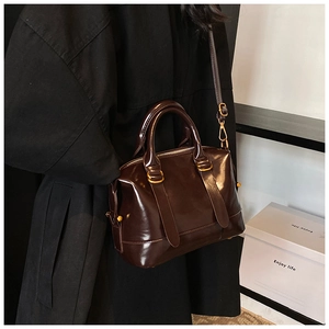 Dettagli della borsa boston in pelle verniciata marrone scuro lucida con finiture dorate