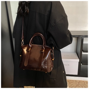 Dettaglio borsa Boston vintage in pelle cerata marrone scuro con finiture dorate