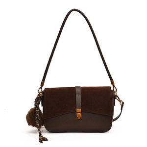 Brown minimalist shoulder bag in matte suede and smooth leather with plush ball charm