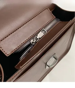 Detailed close-up of premium dark brown lychee texture leather with silver metal zipper