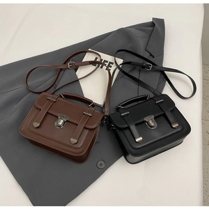 Detail view of retro British style square bags in black and brown matte leather finish