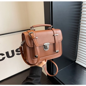 Detailed close-up of brown vintage leather satchel with silver buckle and top handle