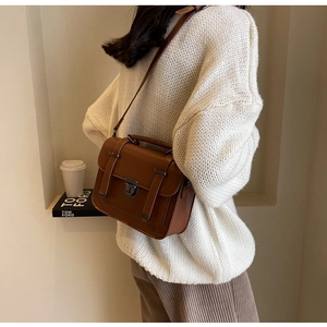 Detailed back view of a vintage brown crossbody bag with a metal buckle and handle