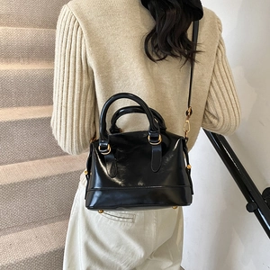 Borsa a bauletto in vernice nera lucida con finiture dorate e doppi manici top