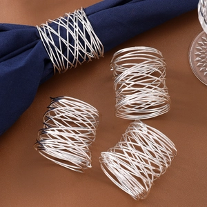 Close-up of wire-wrapped metal napkin rings set on textured leather tabletop